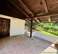 A family house in Malacky with a covered terrace, wooden ceiling, and a garden in the background.