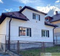 A family house in Sielnica with a white facade and a sloped roof.