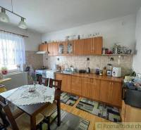 A kitchen in a family house with furniture, a dining table, and a kitchen unit.