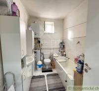 A bathroom in a family house with sanitary ware, cabinets, and a bathtub.