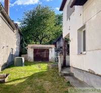 The courtyard of a family house in Sielnica with a shelter and a tree in the background.