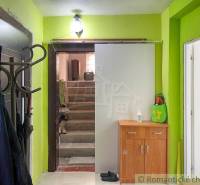 A hallway in a family house with a coat rack, a cabinet, and stairs.