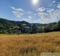 The landscape around Žarnovica, bordered by meadows and forests, under a blue sky.