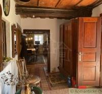 A traditional interior depicts unique properties with massive wooden doors and historical furniture.
