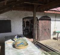 A veranda with wooden doors at a cottage in Rožňava with a table and a basket.