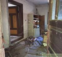 Abandoned interior of a cabin with wooden doors and old furniture.