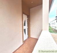 The entrance terrace of a family house in Komárno with white doors on a tiled floor.