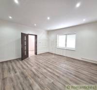 A spacious room in a family house with wooden flooring and white walls.