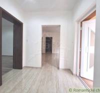 The hallway of a family house with laminate flooring and white walls.