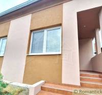 A family house in Komárno with entrance stairs and an elegant facade in two colors.