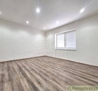 A spacious room with a wooden floor and a window in a family house.