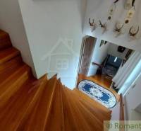 A wooden staircase in a family house with ribbons and hunting trophies on the wall.