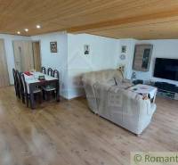 Living room and dining room in a family house with a wooden ceiling and laminate flooring.