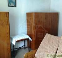 Wooden cabinets and a sofa in the room of a family house.