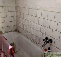 Bathroom with a tiled bathtub in a family house.