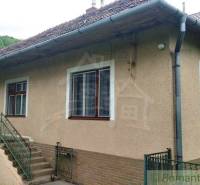 A family house in Fričovce surrounded by greenery with stairs and a veranda.