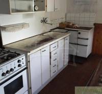 A kitchen in a family house with a gas stove and storage cabinets.