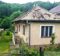 A family house in Fričovce, surrounded by greenery, with a garden and a hilly backdrop.