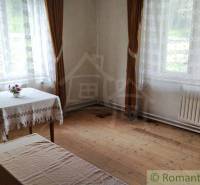Interior of a family house with wooden flooring, a table, and long curtains.