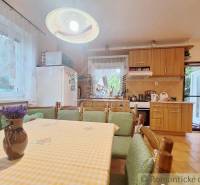 A kitchen in a family house with wooden furniture and floral decoration on the table.