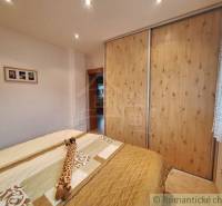 A bedroom in a family house with a bed and built-in wardrobes.