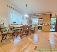 Interior in a family house with a kitchen unit, dining table, and chairs.
