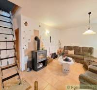 Living room with a tiled stove and ladder staircase in a family house.