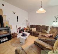 Living room in a family house with a sofa, table, and stove.