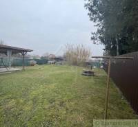 A garden with a lawn by the family house, a gazebo, and a clothesline, wooden fence.