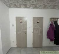 Two wooden interior doors next to a coat rack, tiles, in a family house.