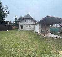 A family house with a gazebo and lawn, surrounded by trees, is located in a quiet area.