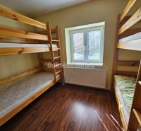 A room with bunk beds, a wooden decor floor, and soft lighting in a family house.