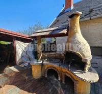 The exterior of a family house in Malá Lehota with a brick chimney and a masonry fireplace on the terrace.