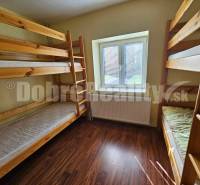 Wooden bunk beds in a room of a family house with a wooden floor.