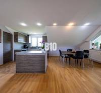 Kitchen with a dining table in a family house, wooden floor, large window.