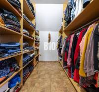 A wardrobe in a family house with shelves full of clothes and coat hangers.