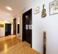 The interior of a family house with artistic decorations on light walls and wooden flooring.