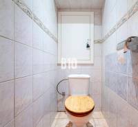 Toilet with tiles in a 3-room apartment, wooden seat, paper holder.