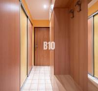A hallway with built-in wooden wardrobes in a 3-room apartment.