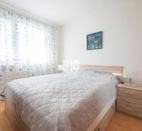 Bedroom in a 3-room apartment with a double bed, a painting, and a nightstand.