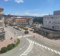 J. Kotáček Street in Zvolen with offices, shops, and cars in the parking lot.