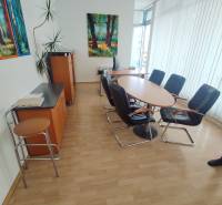 Offices with a round table and chairs, a painting hangs on the wall.