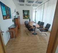 Conference room in the office with chairs, table, and artworks on the walls.