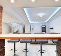 Dining area with brick cladding and bar stools in a family house.