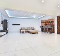 Interior of a family house with a spacious living room, bar stools, and seating furniture.