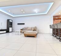 Interior of a family house with furnishings, a sofa, a bar counter, and stools.