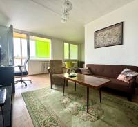 Living room in a 3-room apartment with a sofa, table, and large windows.