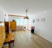 Living room in a two-room apartment with wooden furniture and a TV on a stand.