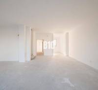 The interior of a family house with a spacious unfinished room and white walls.
