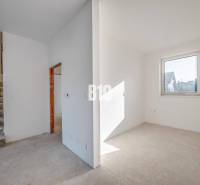 Interior of a family house with an empty room, staircase, and window without flooring.